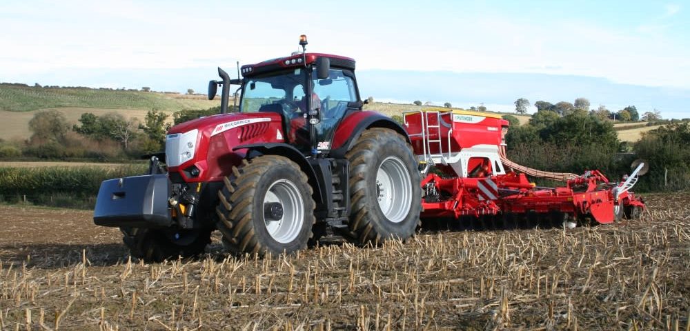 This images shows the McCormick X8 VT-Drive at work with a Pottinger seed drill